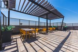 Expansive rooftop terrace featuring a contemporary pergola with slatted wood details, providing dappled shade - 
