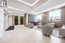 Lobby area featuring large format light-toned tile flooring, recessed ceiling lighting, a textured accent wall with an integrated electric fireplace, and a vertical garden wall - 