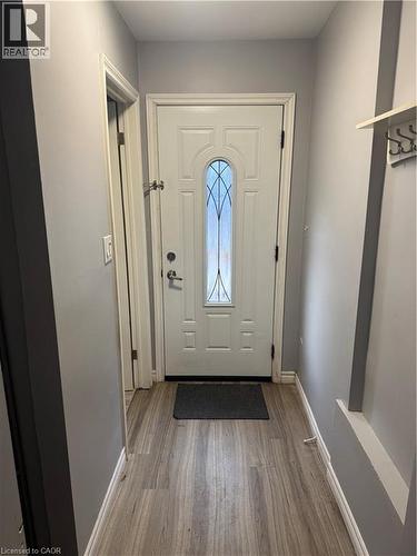 Entryway featuring a panel door with decorative glass inserts, wood-finish flooring, and light gray wall paint - 61 E Waterloo Drive Unit# 61, Kitchener, ON - Indoor Photo Showing Other Room
