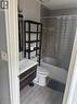 Bathroom featuring a contemporary floating vanity with integrated sink, a white bathtub with tile surround, and wood-finish flooring - 61 E Waterloo Drive Unit# 61, Kitchener, ON  - Indoor Photo Showing Bathroom 