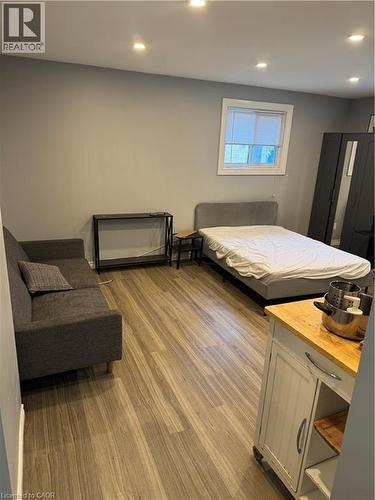 Open-concept living space with wood-finish flooring, recessed lighting, and a window with blinds - 61 E Waterloo Drive Unit# 61, Kitchener, ON - Indoor