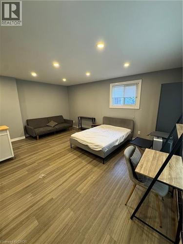 Spacious room featuring wood-finish flooring, recessed lighting, neutral wall tones, and a window with blinds - 61 E Waterloo Drive Unit# 61, Kitchener, ON - Indoor Photo Showing Basement