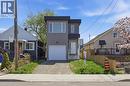 Modern exterior featuring a prominent black flat roofline, gray vertical siding, a white garage door, a white front entry door, and large rectangular windows - 37 Delena Avenue S, Hamilton, ON  - Outdoor With Facade 