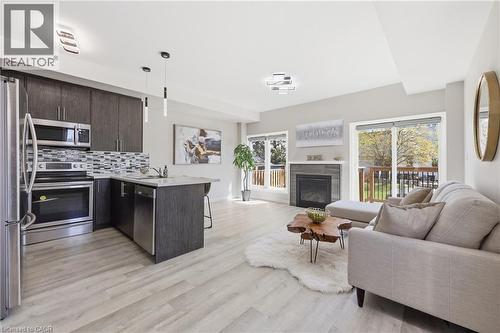 Open-concept living area featuring light wood-finish flooring - 37 Delena Avenue S, Hamilton, ON - Indoor With Fireplace