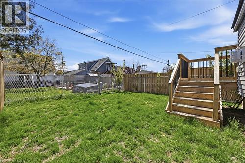 Expansive backyard featuring a natural wood deck with stairs and black metal balusters, a chain link fence, and a wooden privacy fence along the perimeter - 37 Delena Avenue S, Hamilton, ON - Outdoor
