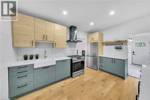 Modern kitchen featuring light wood-finish flooring, white subway tile backsplash, and recessed lighting - 501 Ferguson Avenue N, Hamilton, ON - Indoor Photo Showing Kitchen