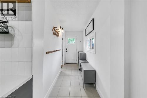 Bright entry hallway featuring light-toned square tile flooring - 501 Ferguson Avenue N, Hamilton, ON - Indoor Photo Showing Other Room