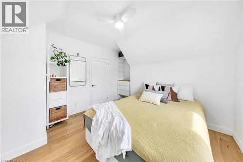 White-painted room featuring wood-finish flooring, a sloped ceiling, and a ceiling fan - 501 Ferguson Avenue N, Hamilton, ON - Indoor Photo Showing Bedroom