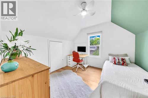 Bright room featuring light wood-finish flooring, a ceiling fan, a window, and a built-in closet - 501 Ferguson Avenue N, Hamilton, ON - Indoor Photo Showing Bedroom