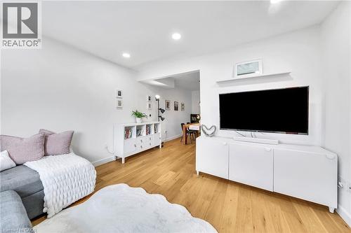 Bright living area featuring wood-finish flooring, recessed lighting, and a white built-in media console - 501 Ferguson Avenue N, Hamilton, ON - Indoor Photo Showing Living Room