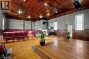 Spacious room featuring wood-finish flooring, a raised stage, and exposed wood ceiling panels - 37 Wellington Street, Cambridge, ON 