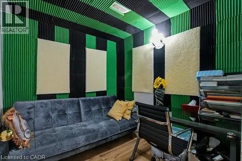 Dedicated room featuring acoustic paneling on walls and ceiling, wood-finish flooring, and a wall-mounted light fixture - 37 Wellington Street, Cambridge, ON 