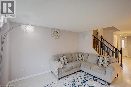 Open-concept living space featuring light wood-finish flooring and a staircase with dark wood newel posts and railings - 53 Prosperity Drive, Kitchener, ON - Indoor Photo Showing Living Room