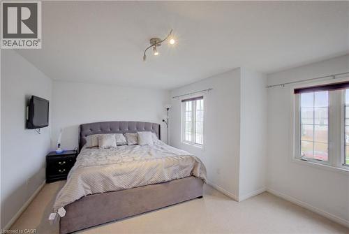 Light-filled interior space featuring track lighting, two distinct windows, and light-toned carpeting - 53 Prosperity Drive, Kitchener, ON - Indoor Photo Showing Bedroom