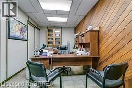 Office space with wood-paneled wall, recessed lighting, built-in shelving, and wood-finish flooring - 9 Meadow Lane S, Hamilton, ON 