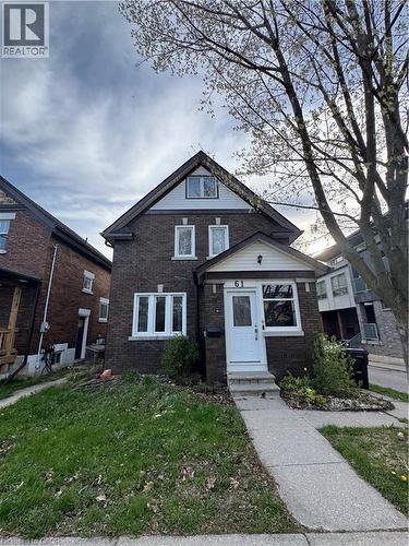 Brick facade residence featuring a white entry door, multiple pane windows, a covered porch, and an asphalt shingle roof - 61 Waterloo Drive, Kitchener, ON - Outdoor With Facade
