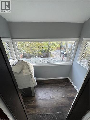 Wood-finish flooring, white baseboards, and neutral grey walls - 61 Waterloo Drive, Kitchener, ON - Indoor Photo Showing Other Room
