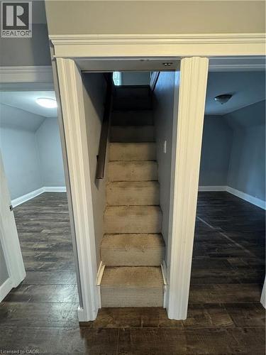 Carpeted staircase framed by white trim, featuring wood-finish flooring in surrounding rooms - 61 Waterloo Drive, Kitchener, ON - Indoor Photo Showing Other Room