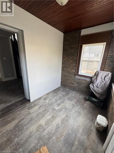 Room featuring wood-finish flooring, a wood-paneled ceiling, and a brick accent wall with a window - 61 Waterloo Drive, Kitchener, ON -  Photo Showing Other Room