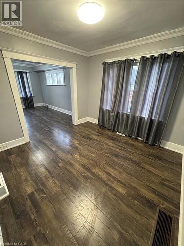 Spacious interior room featuring wood-finish flooring, light gray wall tones, and white crown molding - 61 Waterloo Drive, Kitchener, ON - Indoor Photo Showing Other Room
