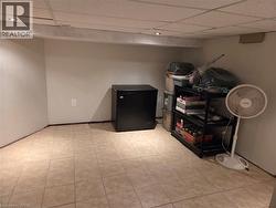 Tiled flooring throughout a neutral-toned room featuring a drop ceiling with recessed lighting - 