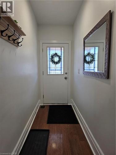 Entryway featuring a white door with decorative glass inserts, wood-finish flooring, and white baseboards - 125 Cavell Avenue, Hamilton, ON - Indoor Photo Showing Other Room