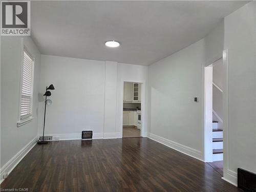 Spacious room featuring wood-finish flooring, white baseboards, and a window with blinds - 125 Cavell Avenue, Hamilton, ON - Indoor Photo Showing Other Room
