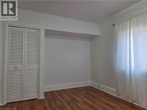 Room featuring wood-finish flooring, white baseboards, and a louvered bi-fold closet door - 125 Cavell Avenue, Hamilton, ON - Indoor Photo Showing Other Room