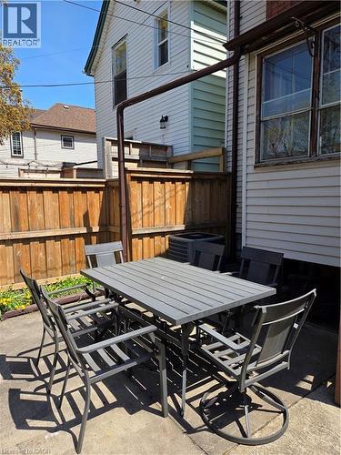 Paved patio area featuring a wooden privacy fence - 125 Cavell Avenue, Hamilton, ON - Outdoor With Deck Patio Veranda With Exterior