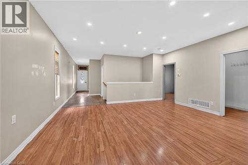 Spacious open-concept interior featuring wood-finish flooring, recessed lighting, and neutral wall tones - 704 Stone Church Road E, Hamilton, ON - Indoor Photo Showing Other Room