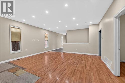 Spacious interior featuring wood-finish flooring, recessed ceiling lighting, neutral wall tones, and white trim - 704 Stone Church Road E, Hamilton, ON - Indoor Photo Showing Other Room