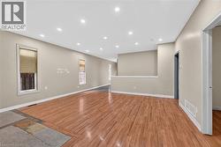 Spacious interior featuring wood-finish flooring, recessed ceiling lighting, neutral wall tones, and white trim - 