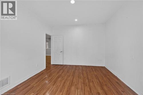Interior room featuring wood-finish flooring, white walls, recessed ceiling lighting, and white baseboards - 704 Stone Church Road E, Hamilton, ON - Indoor Photo Showing Other Room