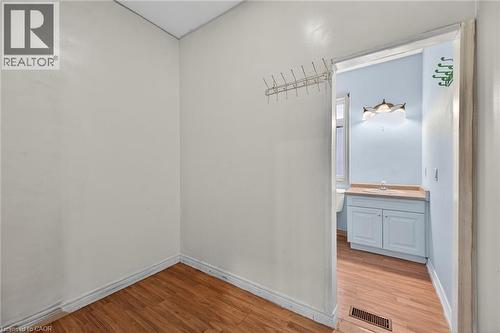 Interior space featuring wood-finish flooring and white baseboards - 704 Stone Church Road E, Hamilton, ON - Indoor Photo Showing Other Room