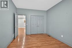 Open-concept interior featuring wood-finish flooring, recessed lighting, and white baseboards - 