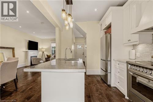 Kitchen with white cabinetry, stainless steel appliances, and a central island featuring an undermount sink and a modern pendant light fixture - 104 Barnesdale Avenue N, Hamilton, ON - Indoor Photo Showing Kitchen With Stainless Steel Kitchen With Upgraded Kitchen