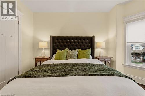 Bedroom with light-toned walls and dark wood-finish flooring - 104 Barnesdale Avenue N, Hamilton, ON - Indoor Photo Showing Bedroom