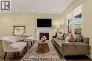 Living area featuring dark wood-finish flooring, a decorative fireplace with a white mantel, and recessed lighting - 104 Barnesdale Avenue N, Hamilton, ON  - Indoor Photo Showing Living Room With Fireplace 