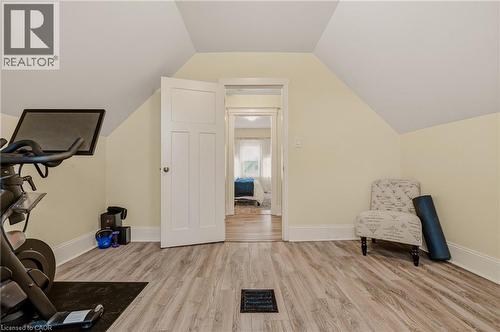 Room featuring sloped ceilings, light wood-finish flooring, and a three-panel interior door - 104 Barnesdale Avenue N, Hamilton, ON - Indoor Photo Showing Gym Room