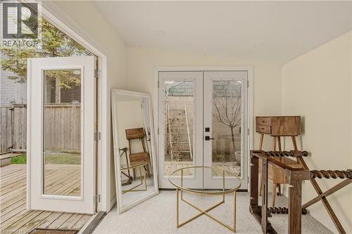 Double French doors opening to an exterior deck, complemented by a second set of French doors - 104 Barnesdale Avenue N, Hamilton, ON - Indoor Photo Showing Other Room