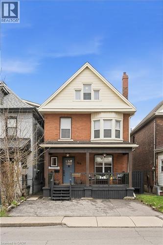 Brick exterior featuring a covered front porch and second-story bay window - 104 Barnesdale Avenue N, Hamilton, ON - Outdoor With Deck Patio Veranda With Facade