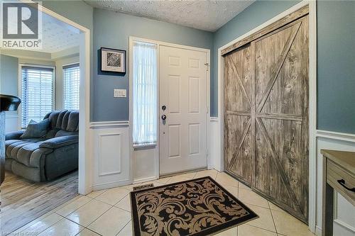 Entry foyer featuring ceramic tile flooring, wainscoting, and a white paneled front door with a full-length sidelight - 146 Locheed Drive, Hamilton, ON - Indoor Photo Showing Other Room