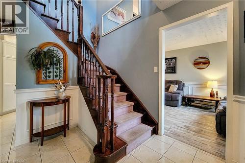 Inviting entryway featuring a wood staircase with carpeted treads, tile flooring, and wainscoting - 146 Locheed Drive, Hamilton, ON - Indoor Photo Showing Other Room
