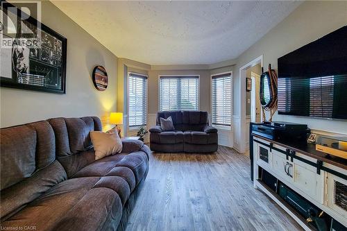 Living area featuring wood-finish flooring, a bay window with blinds, and neutral wall tones - 146 Locheed Drive, Hamilton, ON - Indoor Photo Showing Living Room