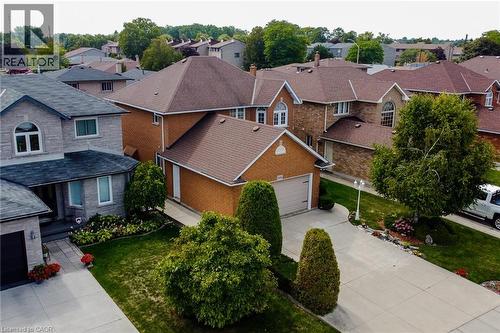Brick exterior residence with a two-car garage, mature landscaping, paved driveway, and a gabled roof - 146 Locheed Drive, Hamilton, ON - Outdoor