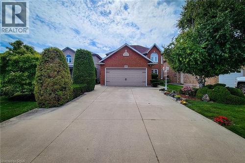 Brick exterior residence featuring an attached garage with a panel door - 146 Locheed Drive, Hamilton, ON - Outdoor