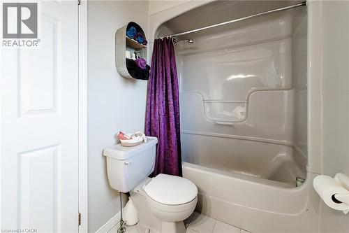 White paneled door opening to a bathroom featuring a white toilet, white tub-shower combination, and light gray walls - 146 Locheed Drive, Hamilton, ON - Indoor Photo Showing Bathroom