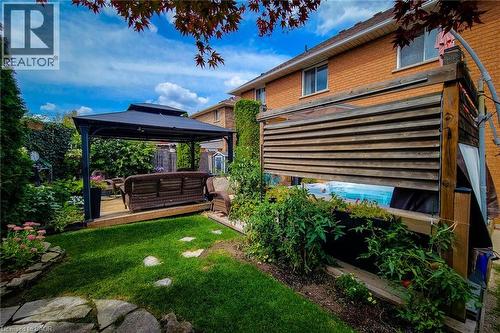 Expansive backyard with a manicured lawn, stone pathway, and mature plantings - 146 Locheed Drive, Hamilton, ON - Outdoor With Deck Patio Veranda