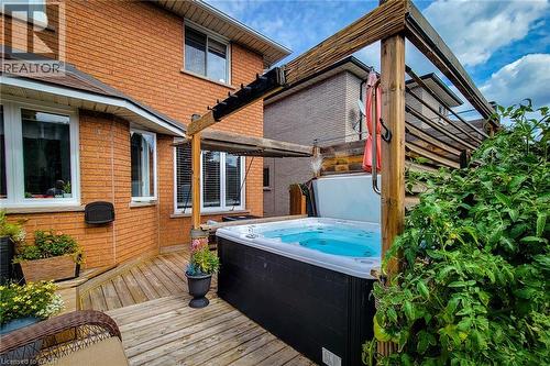 Spacious outdoor deck featuring a built-in hot tub, a pergola structure, and a vibrant green shrub border - 146 Locheed Drive, Hamilton, ON - Outdoor With Deck Patio Veranda With Exterior