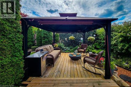Expansive outdoor living area featuring a dark metal gazebo with a fabric canopy, set on a natural wood-finish deck - 146 Locheed Drive, Hamilton, ON - Outdoor With Deck Patio Veranda